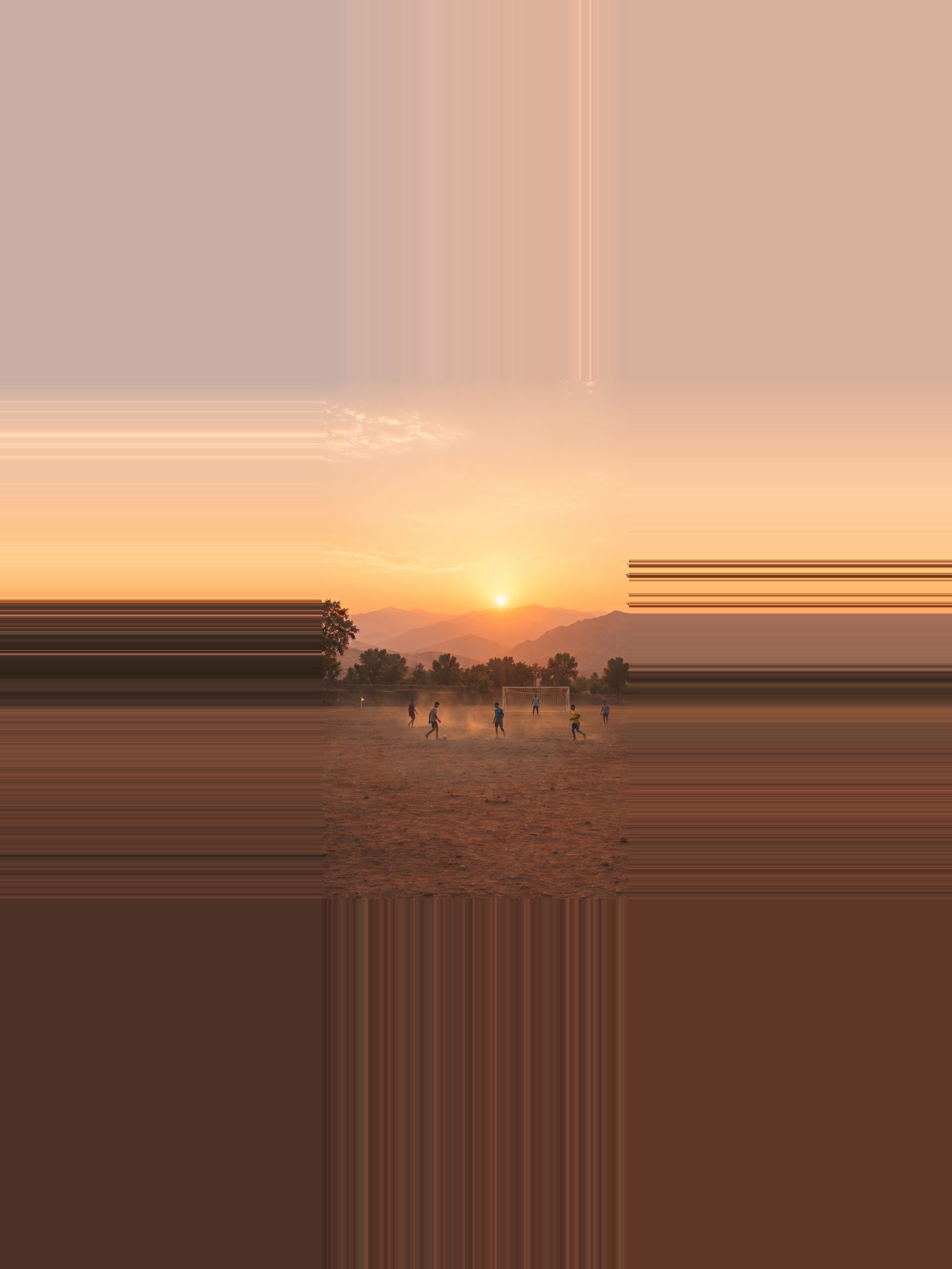 A village football game at sunset